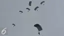 Aksi terjun Payung prajurit TNI AU saat Peringatan HUT TNI AU ke - 70 di Lanud Halim Perdanakusuma, Jakarta, (9/4). Selain Atraksi Terjun Payung juga dipertunjukan berbagai atraksi udara, seperti Flypass Composite Strike. (Liputan6.com/Johan Tallo)