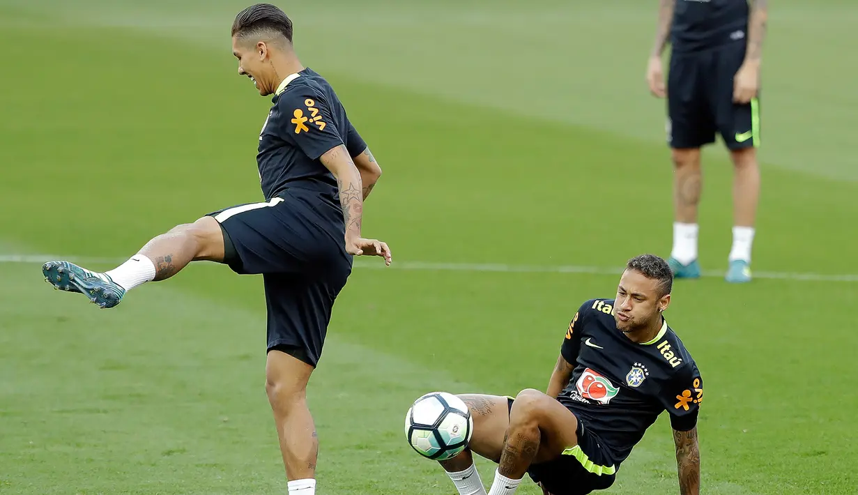 Penyerang Brasil, Roberto Firmino dan Neymar Jr saat mengikuti sesi latihan di Porto Alegre, Brasil, (29/8). Brasil akan menghadapi Ekuador dalam pertandingan sepak bola kualifikasi Piala Dunia 2018 pada 31 Agustus. (AP Photo / Andre Penner)