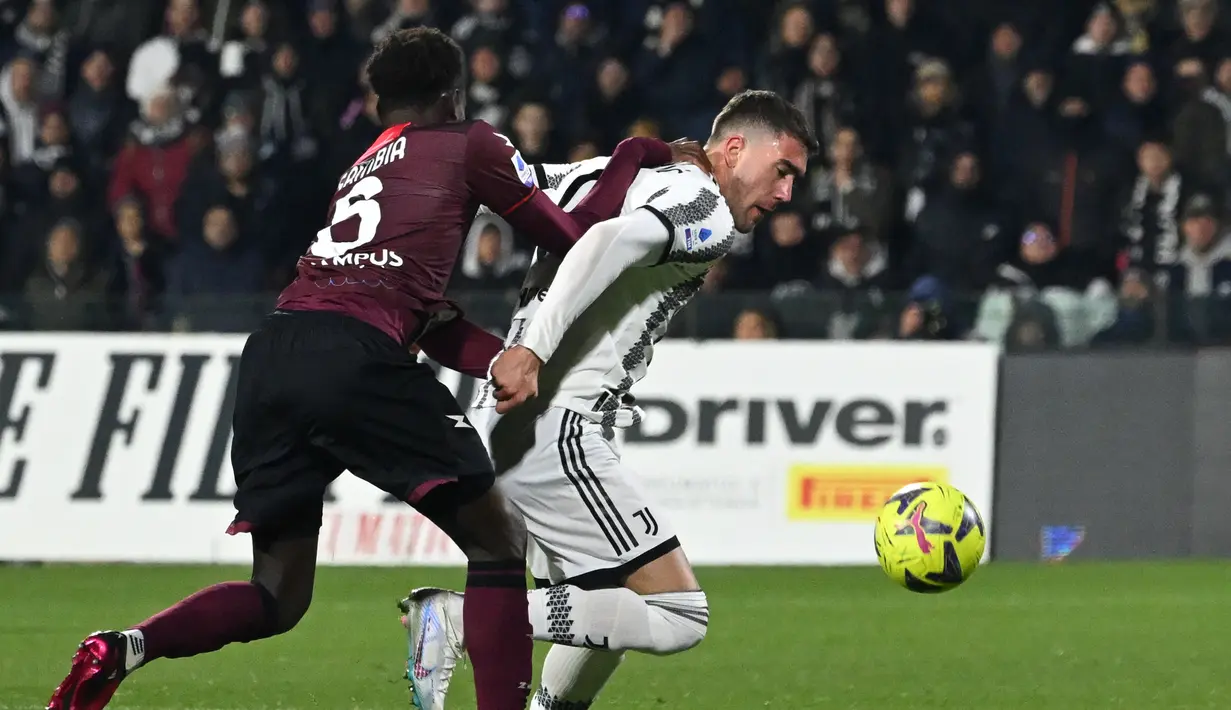 Penyerang Juventus Dusan Vlahovic bekerja di sekitar bek Salernitana Junior Sambia (kiri) pada pekan ke-21 Liga Italia 2022/2023 di Stadio Arechi, Rabu dini hari WIB (8/2/2023). Dusan Vlahovic telah mencetak 93 persen gol dari penalti yang dilakukannya di Serie A (14 dari 15) sejak debutnya, persentase terbaik di antara semua pemain dengan setidaknya 15 penalti yang diambil. (Photo by Andreas SOLARO / AFP)