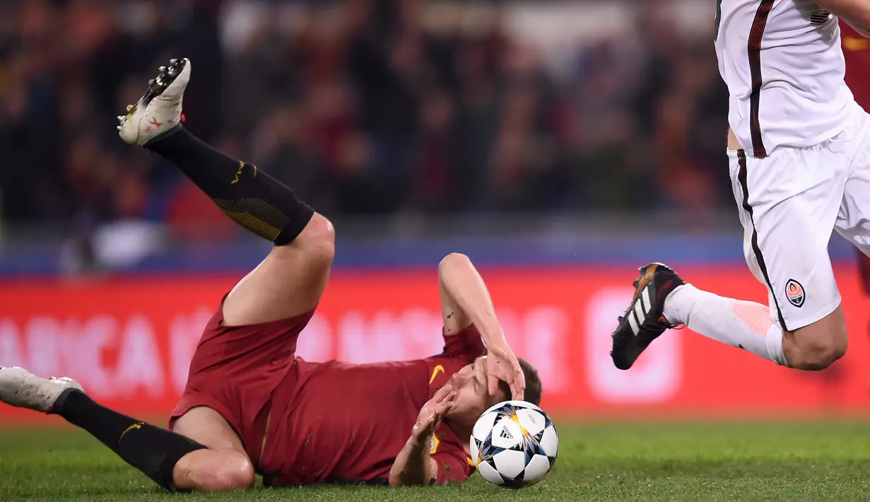 Pemain AS Roma, Edin Dzeko jatuh saat berebut bola dengan pemain Shakhtar Donetsk, Ivan Ordets pada leg kedua 16 besar Liga Champions di Rome Olympic stadium, (13/3/2018). AS Roma Menang 1-0. (AFP/Filippo Monteforte)