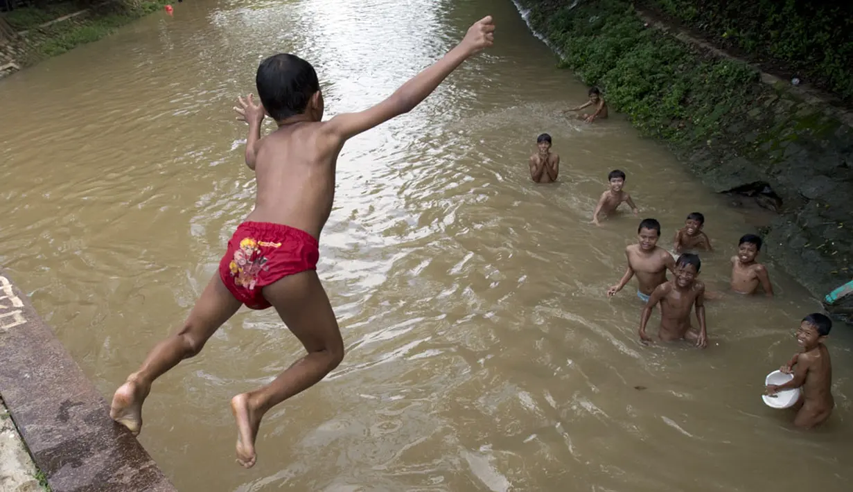 Tanpa menghiraukan bahaya, beberapa anak asyik bermain di pinggir Sungai Kalimalang, Jakarta, (23/7/2014). (ANTARA FOTO/Rosa Panggabean)