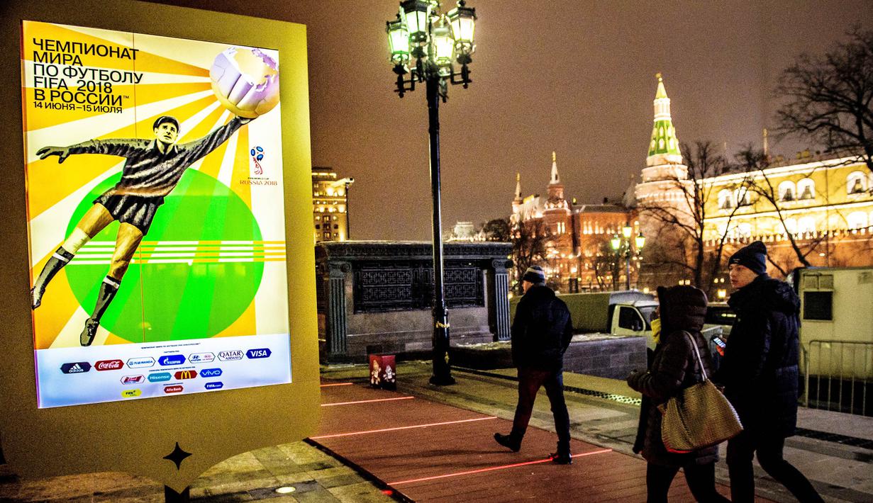 Warga melintas di depan poster pengumuman drawing Piala Dunia 2018 di Kremlin, Moscow, Rabu (29/11/2017). Drawing 32 peserta Piala Dunia 2018 akan dilakukan pada Jumat (1/12/2017) di Rusia. (AFP/Malden Antonov)