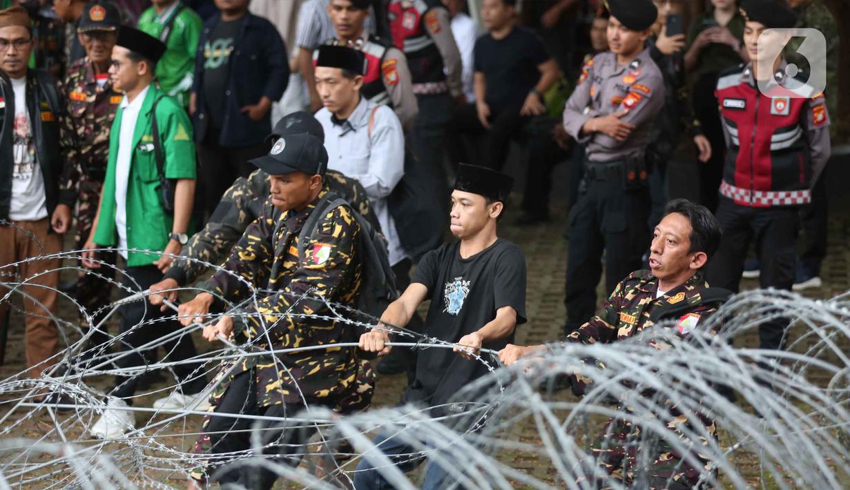 Untuk diketahui, Yaqut Cholil Qoumas merupakan tersangka dugaan tindak pidana korupsi terkait kuota haji untuk penyelenggaraan ibadah haji Indonesia tahun 2023-2024. Tampak dalam foto, anggota dan simpatisan Barisan Ansor Serbaguna (Banser) saat berunjuk rasa di depan gedung Merah Putih Komisi Pemberantasan Korupsi (KPK), Jakarta, Kamis (12/3/2026). (Liputan6.com/Helmi Fithriansyah)