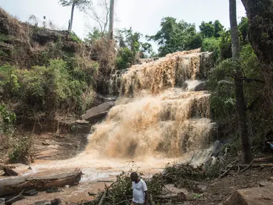 Warga berada di dekat air terjun Kintampo, Ghana (21/3). 20 siswa tewas setelah pohon tumbang dan menimpa mereka yang tengah berada di kolam air terjun pada Minggu (19/3) waktu setempat. (AFP Photo / Cristina Aldehuela)