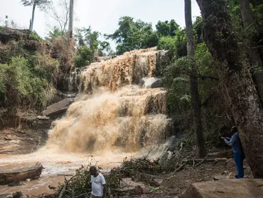 Warga berada di dekat air terjun Kintampo, Ghana (21/3). 20 siswa tewas setelah pohon tumbang dan menimpa mereka yang tengah berada di kolam air terjun pada Minggu (19/3) waktu setempat. (AFP Photo / Cristina Aldehuela)