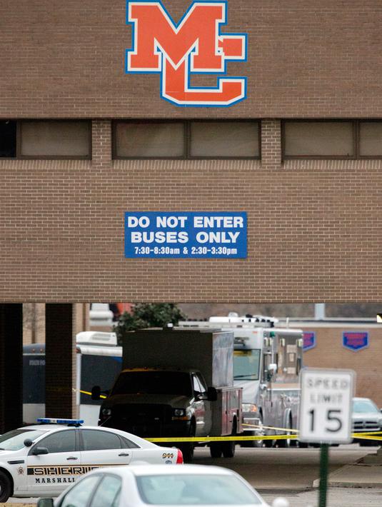 Petugas memasang garis polisi pascapenembakan mematikan di SMA Marshall County High School, Benton, Kentucky, Amerika Serikat, Selasa (23/1). Selain menewaskan dua siswa, 17 lainnya dilaporkan terluka. (Ryan Hermens/The Paducah Sun via AP)