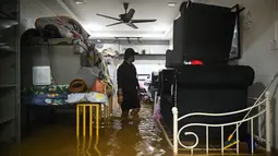 Seorang pria melihat harta bendanya sebelum dievakuasi dari daerah banjir di Yong Peng, negara bagian Johor Malaysia, Sabtu (4/3/2023). Pihak berwenang telah mendirikan lebih dari 200 tempat penampungan bantuan untuk warga yang terlantar akibat banjir, kata Badan Penanggulangan Bencana Nasional Malaysia. (Photo by Mohd RASFAN / AFP)