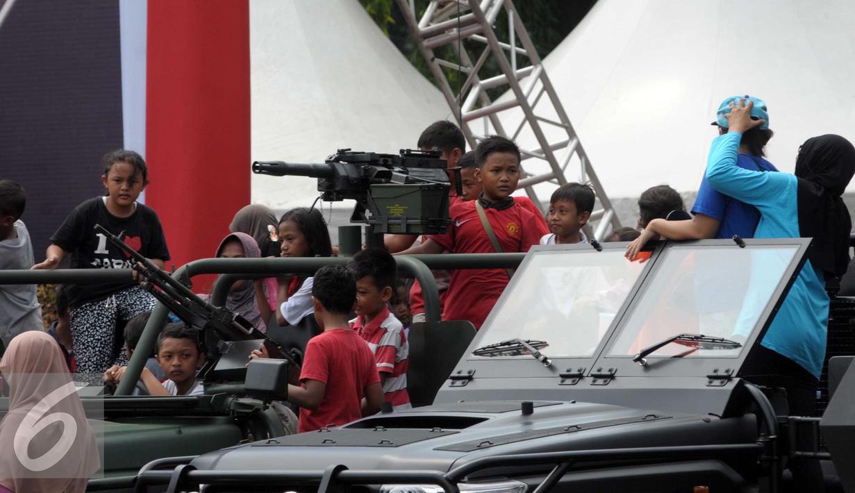Sejumlah warga menaiki kendaraan tempur saat HUT Kopassus ke-64, Jakarta, (16/4). HUT mengangkat Tema Loyalitas, Moralitas dan Integritas demi mewujudkan Prajurit Hebat Profesional dan Dicintai Rakyat. (Liputan6.com/Helmi Afandi)