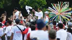 Capres 01 Joko Widodo didampingi Iriana Jokowi dan Kaesang Pangarep melempar kaus seusai 'Konser Putih Bersatu' di Stadion GBK, Jakarta, Sabtu (13/4). Pasangan Capres dan Cawapres 01 menggunakan kereta kencana seusai Konser Putih Bersatu menuju lokasi debat. (Liputan6.com/Herman Zakharia)