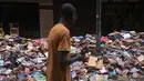 Ribuan buku rusak terlihat di jalan setelah hujan lebat membanjiri toko buku di Petropolis, Brasil, 19 Februari 2022. Sebanyak 136 jenazah telah diidentifikasi hingga kini, menurut pejabat pertahanan sipil, di kota wisata yang biasanya indah, sekitar 60 km utara Rio de Janeiro. (MAURO PIMENTEL/AFP)