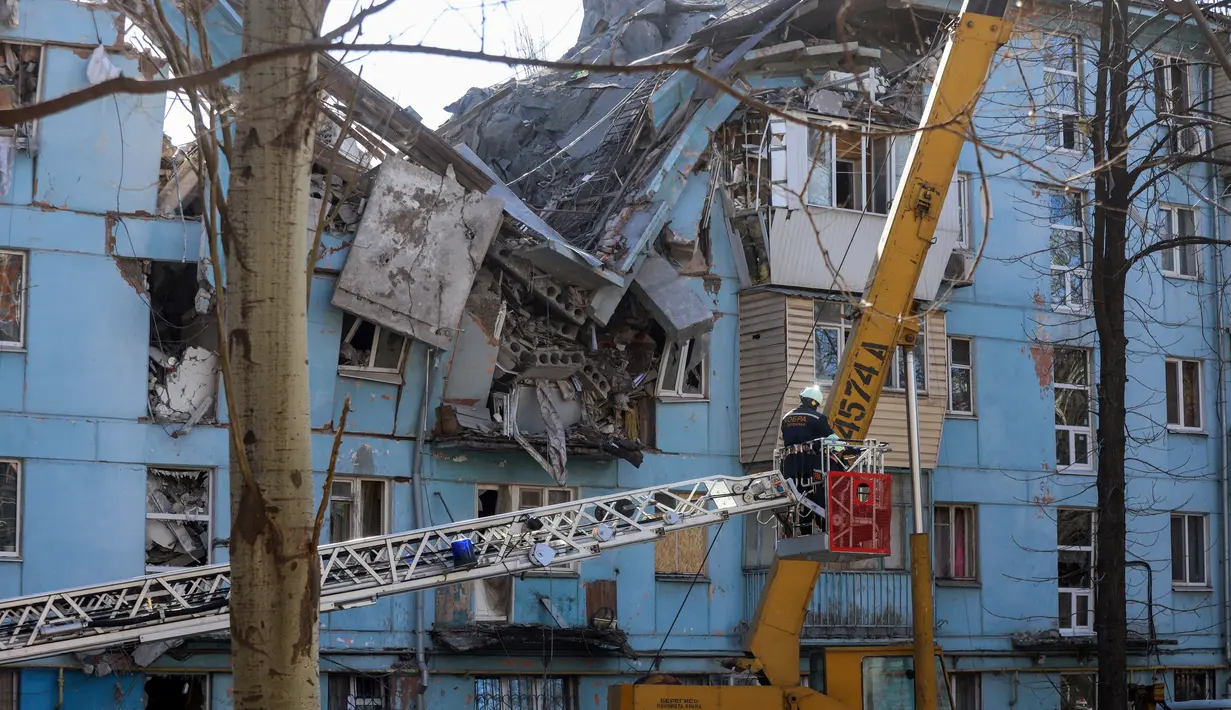 Tim penyelamat Ukraina di eskalator bekerja di bangunan tempat tinggal lima lantai yang hancur setelah serangan rudal di tengah invasi Rusia ke Ukraina di Zaporizhzhia pada 2 Maret 2023. Serangan Rusia di sebuah blok apartemen di kota Zaporizhzhia, Ukraina selatan telah menewaskan sedikitnya tiga orang, kata pihak berwenang setempat pada 2 Maret, saat operasi pencarian sedang berlangsung. (AFP/Katerina Klochko)