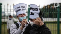 Dua pengungsi Afghanistan saat berunjuk rasa di kawasan Monas, Jakarta, Rabu (19/1/2022). Mereka menuntut kejelasan untuk berangkat ke negara ketiga setelah lama tinggal di pengungsian. (Liputan6.com/Faizal Fanani)