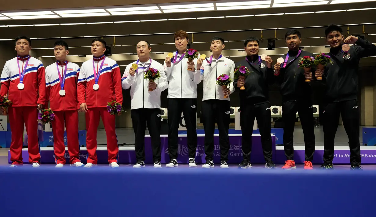 Tim peraih medali berpose dalam upacara penghargaan menembak pistol cepat nomor 25 meter beregu putra di Fuyang Yinhu Sports Centre pada Asian Games ke-19 di Hangzhou, China, Senin, 25 September 2023. (AP Photo/Aijaz Rahi)