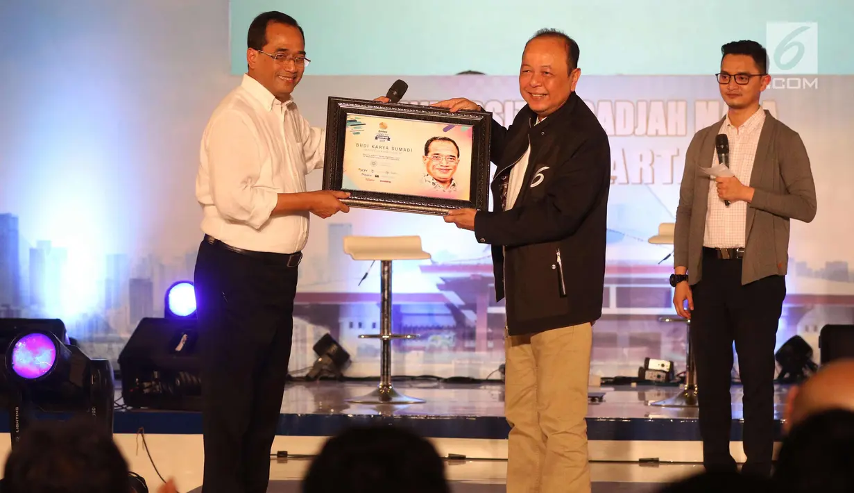 Pemimpin Redaksi SCTV, Indosiar, dan Liputan6.com Mohamad Teguh (tengah) memberikan cinderamata kepada Menhub Budi Karya Sumadi (kiri) di EGTC 2017 di Graha Sabha Pramana Universitas Gadjah Mada, Yogyakarta, Selasa (31/10). (Liputan6.com/Helmi Afandi)