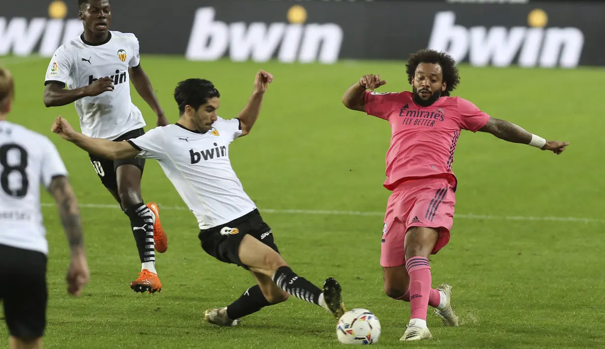 Bek Real Madrid, Marcelo (kanan) berebut bola dengan gelandang Valencia, Carlos Soler pada lanjutan La Liga di Stadion Mestalla, Selasa (9/11/2020) dinihari WIB. Real Madrid kalah telak 1-4 dari tuan rumah Valencia. (AP Photo/Alberto Saiz)