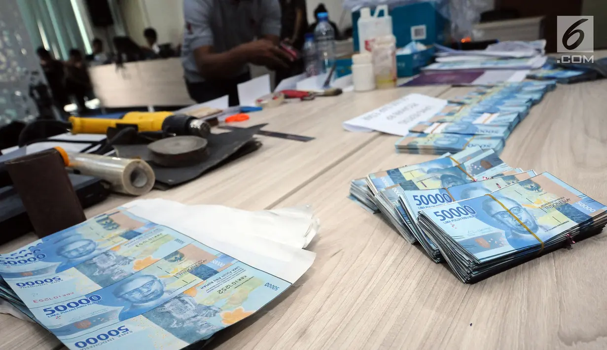 Tumpukan uang palsu Rp 50.000,- emisi 2016 saat rilis di Bareskrim Mabes Polri, Jakarta, Senin (29/1). Dirtidpid Ekonomi dan Khusus Bareskrim Polri menangkap empat tersangka di wilayah Cikarang. (Liputan6.com/Helmi Fithriansyah)