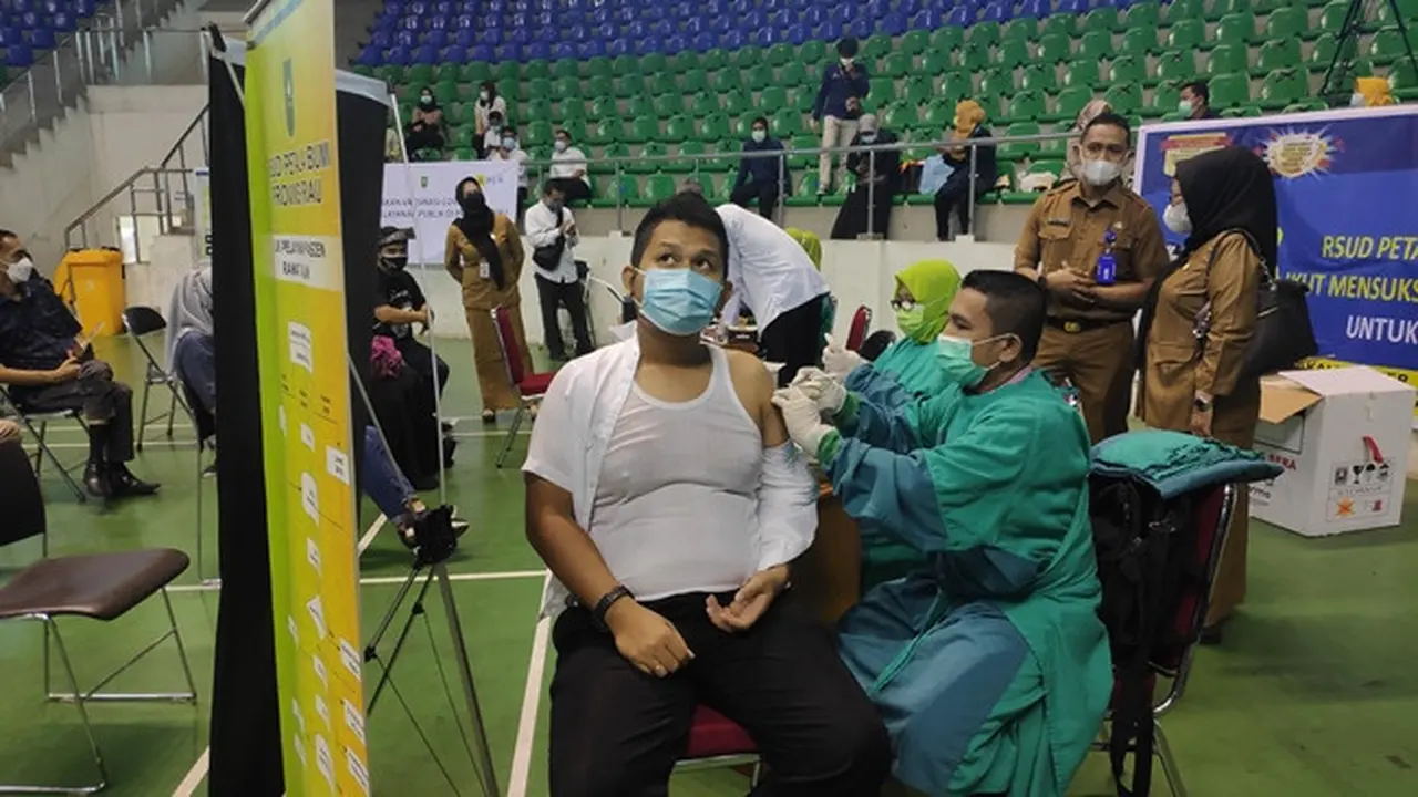 Seorang petugas pelayanan publik di Riau menerima vaksin Covid-19.