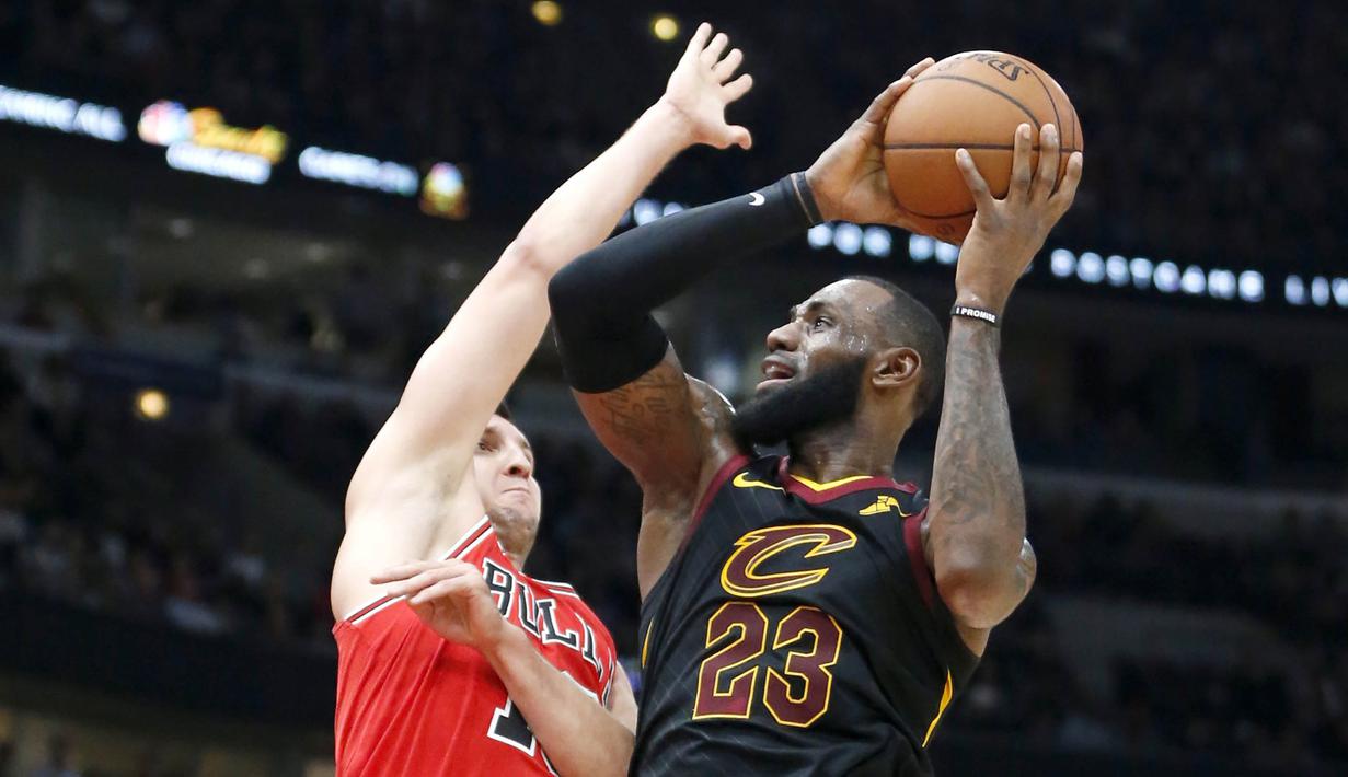 Pebasket Cleveland Cavaliers, LeBron James, dihadang pebasket Chicago Bulls, Paul Zipser, pada laga NBA di United Center, Selasa (5/12/2017). Cleveland Cavaliers menang 113-91 atas Chicago Bulls. (AP/Charles Rex Arbogast)