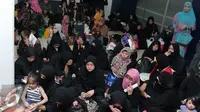 Sejumlah Tenaga Kerja Indonesia (TKI) menunggu bus di Bandara Soekarno Hatta,Tangerang, Rabu (11/11). Sebanyak 450 WNI overstayers dan TKI undocumented dari Jeddah, Arab Saudi dipulangkan pemerintah Indonesia. (Liputan6.com/Angga Yuniar)