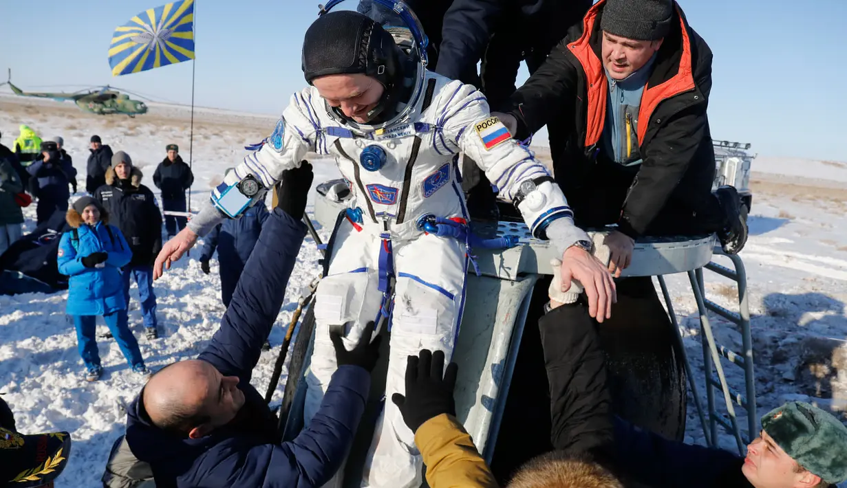 Tim penyelamat antariksa Rusia membantu kosmonot Rusia Sergey Ryazanskiy sesaat setelah pendaratan kapsul Soyuz MS-05 di Kazakhstan (14/12). (AP/ Dmitri Lovetsky/Pool)