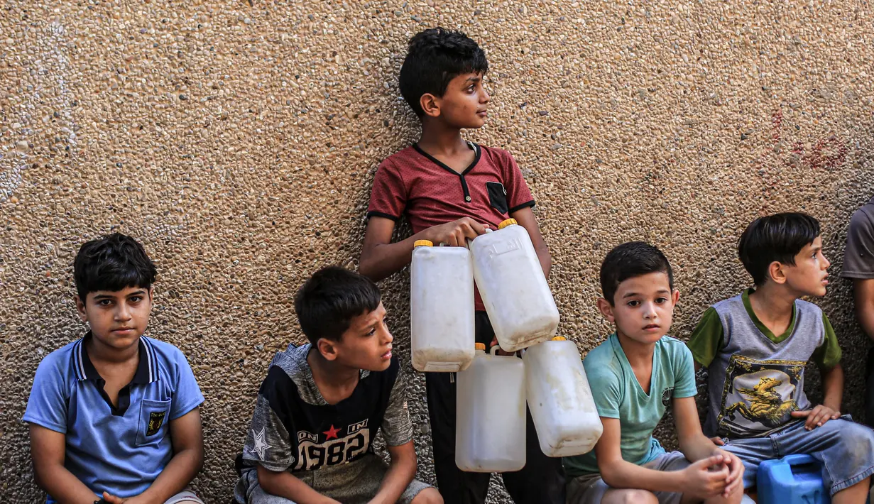 Anak-anak menunggu untuk mengisi jeriken mereka dengan air minum dari pabrik desalinasi air di kamp pengungsi Jabalia, Jalur Gaza, Palestina, 24 Agustus 2020. Warga Palestina mengeluhkan pemutusan aliran air akibat krisis pemadaman listrik di Jalur Gaza yang diblokade.(Xinhua/Rizek Abdeljawad)