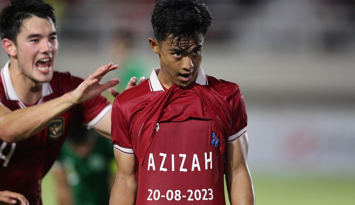 Pemain Timnas Indonesia U-23, Pratama Arhan (kanan), memamerkan tulisan "Azizah, 20-08-2023," kepada sejumlah wartawan yang meliput setelah mencetak gol kedua ke gawang Timnas Turkmenistan U-23 dalam pertandingan grup K Kualifikasi Piala Asia U-23 2024 yang berlangsung di Stadion Manahan, Solo, Selasa (12/9/2023). (Bola.com/Arief Bagus)