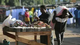Seorang wanita menyiapkan meja untuk menjual makanan ringan di pinggiran padat Mbare di Harare, Zimbabwe, Rabu (26/2/2020). Negara yang terkurung daratan ini berbatasan dengan Afrika Selatan di sebelah selatan, Botswana di barat, Zambia di utara dan Mozambik di timur. (AP Photo/Tsvangirayi Mukwazhi)
