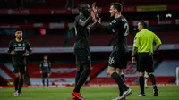 Penyerang Liverpool, Sadio Mane berselebrasi (kiri) berselebrasi dengan Andrew Robertson usai mencetak gol ke gawang Arsenal pada pertandingan lanjutan Liga Inggris di Stadion Emirates di London (15/7/2020). Arsenal menang tipis 2-1 atas Liverpool. (Paul Childs/Pool via AP)