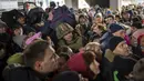 Seorang tentara Ukraina mencoba membubarkan kerumunan saat mereka mendorong untuk memasuki kereta api ke Lviv di Stasiun Kiev, Ukraina, 4 Maret 2022. (AP Photo/Emilio Morenatti)