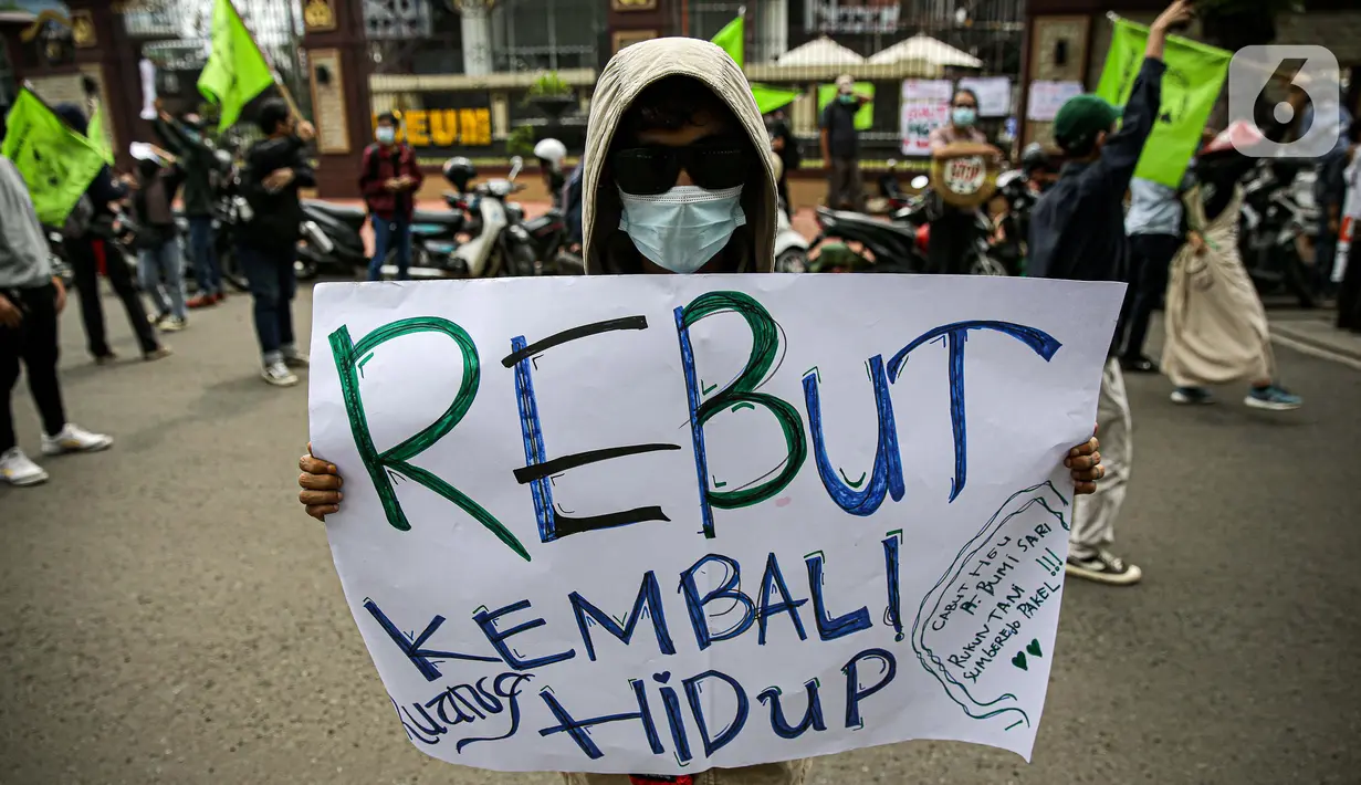 Massa yang tergabung dalam Rukun Tani Sumberejo Pakel membentangkan spanduk saat melakukan aksi di depan Mabes Polri, Jakarta, Kamis (17/6/2021). Massa juga meminta penghentian kriminalisasi yang dialami oleh dua petani Pakel. (Liputan6.com/Faizal Fanani)