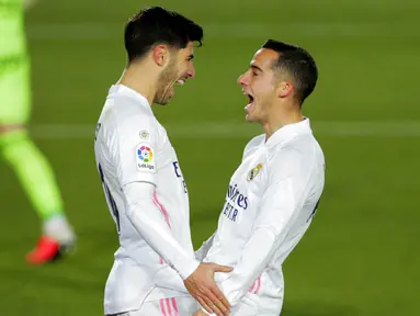 Gelandang Real Madrid, Marco Asensio, melakukan selebrasi bersama Lucas Vazquez usai mencetak gol ke gawang Celta Vigo pada laga Liga Spanyol di Stadion Alfredo Di Stefano, Sabtu (2/1/2021). Real Madrid menang dengan skor 2-0. (AP/Manu Fernandez)