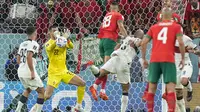 Kiper Timnas Portugal, Diogo Costa berusaha menghalau bola dari ancaman para pemain Timnas Maroko dalam laga babak perempatfinal Piala Dunia 2022 di Al Thumama Stadium, Doha, Qatar, Sabtu (10/12/2022) malam WIB. (AP/Ariel Schalit)