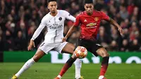 Aksi Marcus Rashford mencoba melewati Marquinhos pada laga leg 1, babak 16 Besar Liga Champions yang berlangsung di Stadion Old Trafford, Manchester, Rabu (13/2).  Manchester United kalah 0-2 dari PSG. (AFP/Paul Ellis)