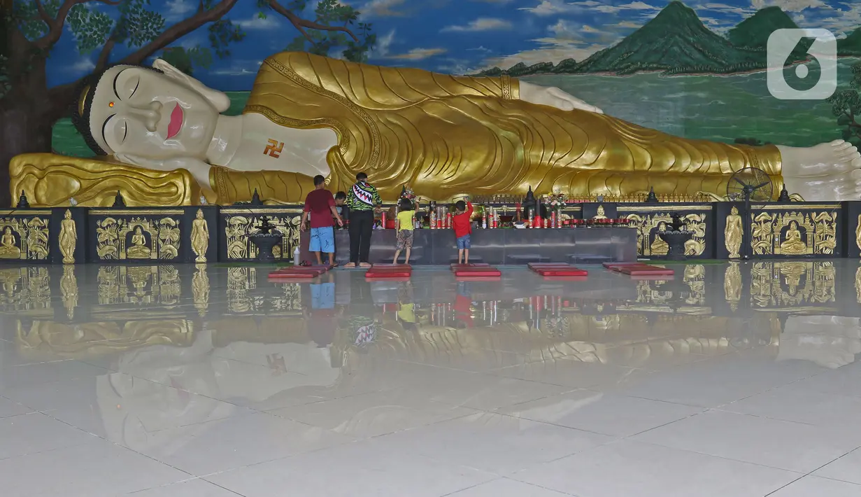 Pekerja membersihkan patung Buddha Tidur di Vihara Buddha Dharma dan 8 Pho Sat, Desa Tonjong, Tajurhalang, Bogor, Selasa (25/5/2021). Vihara itu mulai dihias dan dibersihkan untuk memberi kenyamanan bagi umat Budha yang akan beribadah saat peringatan Hari Raya Waisak. (Liputan6.com/Herman Zakharia)