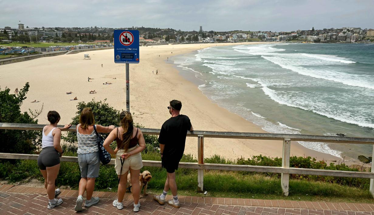 Orang-orang terlihat di Pantai Bondi, Sydney, Australia pada Senin 15 Desember 2025, sehari setelah penembakan. Suasana sekitar Pantai Bondi, Sydney, Australia mulai kembali kondusif. (Saeed KHAN/AFP)