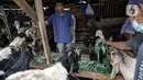 Penjual memberi makan hewan kurban yang dijual di Pasar Kambing, Tanah Abang, Jakarta, Selasa (13/7/2021). PPKM Darurat juga menyebabkan pengiriman hewan kurban dari luar kota terhambat sehingga stok kambing dan sapi terbatas. (Liputan6.com/Faizal Fanani)
