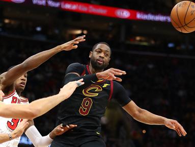 Pemain Cleveland Cavaliers, Dwyane Wade #9 memberikan umpan kepada rekannya saat diadang para pemain Chicago Bulls pada laga NBA basketball game di Quicken Loans Arena, Cleveland, (21/12/2017). Cleveland menang 115-112.  (Gregory Shamus/Getty Images/AFP)