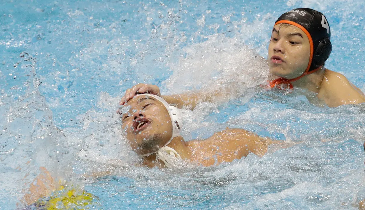 Pemain Indonesia Delvin Fellicino (kiri) berebut bola dengan pemain Malaysia pada pertandingan polo air putra SEA Games 2019 di New Clark City, Tarlac, Filipina, Jumat (29/11/2019). Indonesia meraih medali emas setelah memuncaki klasemen dengan raihan 7 poin. (AP Photo/Aaron Favila)