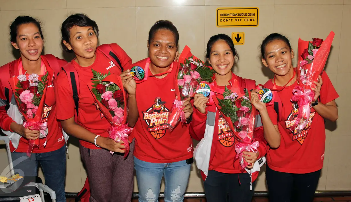 Tim nasional basket putri Indonesia saat tiba di Bandara Soekarno-Hatta, Banten, Selasa (16/6/2015). Mereka berhasil mengawinkan dua medali perak di cabang olahraga basket pada SEA Games 2015 di Singapura. (Liputan6.com/Helmi Afandi)