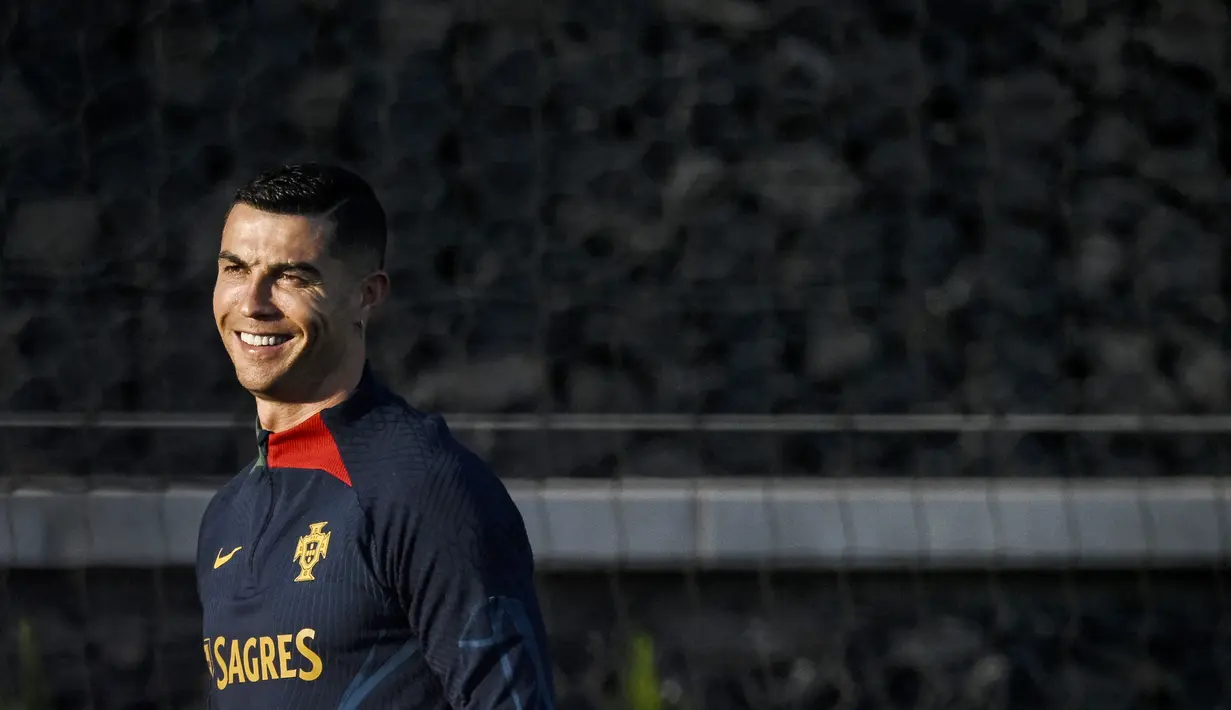 Pemain Portugal, Cristiano Ronaldo, tersenyum saat mengikuti sesi latihan jelang menghadapi laga Kualifikasi Euro 2024 di Lisbon, (20/3/2023). (AFP/Patricia De Melo Moreira)