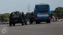 Anggota Paskhas TNI AU mencoba mendekati sebuah bus berisi pelaku teror saat unjuk kebolehan simulasi penyelamatan sandera dalam rangkaian acara HUT TNI AU di Halim Perdanakusuma, Minggu (9/4). TNI AU memperingati HUT ke-71. (Liputan6.com/Faizal Fanani)