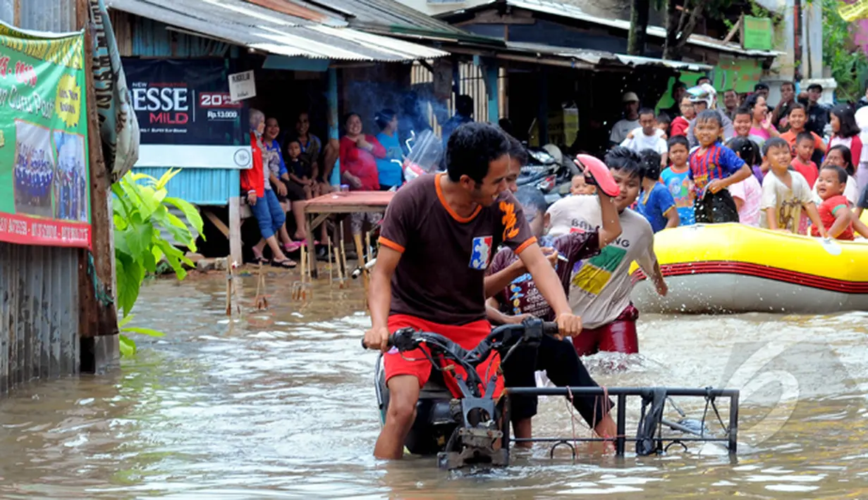 Hujan yang turun sejak Minggu (8/2) lalu, mengakibatkan kawasan perumahan mewah Garaharaya di Tangerang, Banten terendam air setinggi lebih kurang 90 cm. Tampak sejumlah bocah dievakuasi, Selasa (10/2/2015). (Liputan6.com/Faisal R Syam)