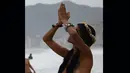 Kelakuan wanita yang mengumbar payudaranya saat melakukan ritual untuk Lemanja ini menjadi pusat perhatian para pengunjung di Pantai Arpoador, Rio de Janeiro, Brasil, Senin (2/2/2015). (AFP Photo/Yasuyoshi Chiba)