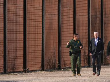 Presiden Amerika Serikat Joe Biden berjalan dengan agen Patroli Perbatasan AS di sepanjang perbatasan AS-Meksiko di El Paso Texas, AS, 8 Januari 2023. Kunjungan ini untuk melihat langsung keamanan perbatasan dengan perlintasan imigran yang terus meningkat. (AP Photo/Andrew Harnik)