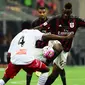 Striker AC Milan, Mario Balotelli, saat berupaya melewati gelandang Carpi, Isaac Cofie, pada laga lanjutan Serie A, di San Siro, Kamis atau Jumat (22/4/2016) dini hari WIB. (AFP/Giuseppe Cacace). 