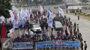 Ribuan buruh melakukan longmarch membawa spanduk menuju Istana Merdeka, Jakarta, Sabtu (6/2/2016). Dalam aksi tersebut mereka meminta agar tidak terjadi PHK secara besar-besaran. (Liputan6.com/Angga Yuniar)