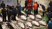 Orang-orang menghadiri tradisi lelang Tahun Baru di Pasar ikan Toyosu, Tokyo, Minggu (5/1/2020). Lelang ikan ini adalah kegiatan rutin usai Tahun Baru yang biasanya diadakan menjelang fajar di pasar ikan Toyosu. (Kazuhiro NOGI / AFP)