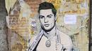Sebuah mural dengan gambar bintang Juventus, Cristiano Ronaldo, yang terdapat di Milan, Senin (19/3). Mural berjudul Cristiano's Secret ini karya seniman Italia, TvBoy. (AFP/Miguel Medina)
