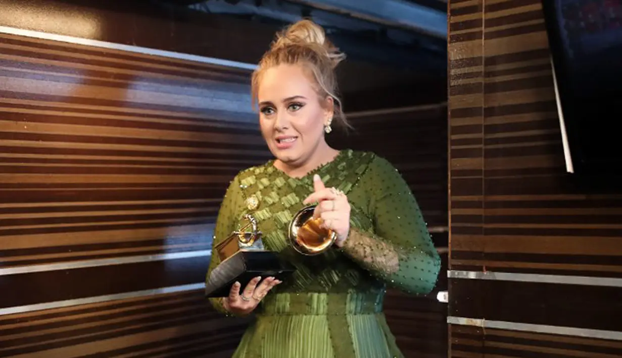 Dalam ajang bergengsi Grammy Awards 2017, Adele memang berhasil membawa pulang lima piala kemenangan dalam lima nominasi. Namun saat menerima salah satu piala, di atas panggung Adele malah melakukan hal yang tak disangka. (AFP/Bintang.com)