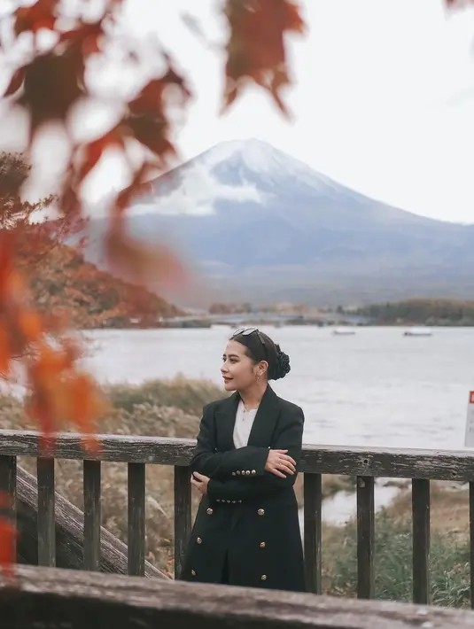 OOTD liburan yang menarik mengenakan blazer ala Prilly. Ia berpose dengan latar Gunung Fuji, mengenakan inner putih yang ditumpuk dengan blazer hitam dengan banyak kancing emasnya. [Foto: Instagram/prillylatuconsina96]